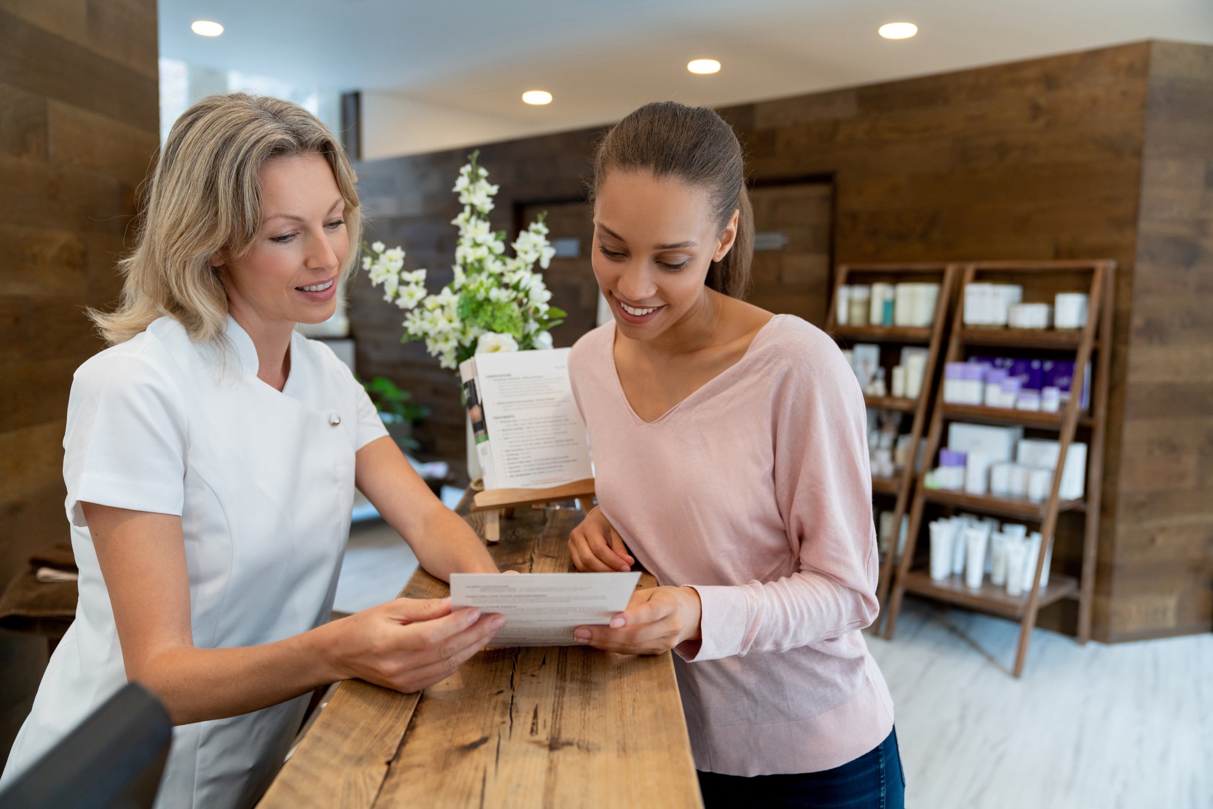 Spa manager showing a brochure to a happy customer